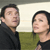Two people in a pixelated image with one wearing dark clothing and the other in a green top against a light background.