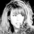 Black-and-white pixelated image of a person with long hair and a dark streak on the left side, set against a solid black background.