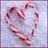 A pixelated heart shape formed by pink and red curved lines on a light blue background with subtle purple accents.
