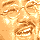 Pixelated image of a man with brown hair and mustache, wearing glasses, in two color variations: orange-brown tones on top and purple-pink tones below.