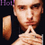 Pixelated image of a person with short hair wearing dark clothing, holding hands in front of the chest; left side shows 'Hot' text and right side has red heart symbol.