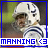 Pixelated image of a football player in white helmet and uniform with blue stripes, wearing a face mask, positioned against blurred green and brown background.
