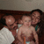 Three people pose closely together in a pixelated image with a dark brown background and light gray upper section.