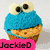 A pixelated cupcake with blue frosting and large white eyes, labeled 'JackieD' on a pink background.