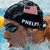 A swimmer wearing a black cap with an American flag patch and 'FRANK' text, in water with yellow lane markers.