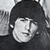 Pixelated grayscale image of a person with short dark hair, neutral expression, and light skin tone, cropped to show head and shoulders against a blurred background.