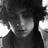 Black-and-white image of a person with curly hair in three distinct poses showing head tilt and eye position changes.