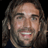 Pixelated static image of a person's face with long hair and beard, displayed as a 48x48 buddy icon on black background.