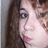 Pixelated close-up of a person with long dark hair, light skin, blue eyes, and pink lips against a gray background.
