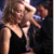 A woman in a black dress and a man in dark clothing interact in a dimly lit setting with text reading "Put on your boogie shoes" on the right.
