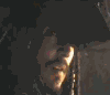 Animated sequence of a figure in dark clothing with metallic accents, showing facial expression changes from neutral to smiling