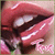 A pixelated close-up of a person's mouth with parted lips, showing teeth and inner mouth details against a light background.