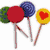Four lollipops with colorful round heads on sticks, one featuring a red heart symbol.