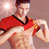 Static pixelated image of a person in red athletic attire with dark trim, cropped to show upper body and arm against light background.