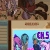Pixelated static image showing a blurred figure with dark hair and a red garment above a blue-tinted section with purple and teal shapes and partial text.
