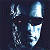 Pixelated blue and white icon with four distinct shapes against a dark background, including a tall vertical form, a curved shape, and two angular elements.