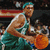 Pixelated image of a basketball player in teal and white uniform holding an orange ball, with blurred background elements.