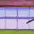 Animated sequence of a character in purple clothing performing martial arts movements on a wooden platform with a -patterned background