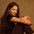 A woman with long dark hair sits against a brown background, arms crossed over her knees. Green text on the right reads "Original Icons .com".