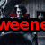 A pixelated image shows a partial view of a character with red accents and dark clothing, overlaid by bold red text on black background.