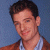 A 50x50 pixel animated buddy icon featuring a person in a brown jacket over a light blue shirt on the left side and green text reading "Original Icons .com" on a dark green background on the right side, displayed as part of an animated contact sheet with two frames.