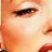 Pixelated close-up of a human eye with eyelashes and eyebrow, showing warm skin tones and partial facial features on a light background.