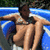 Pixelated image of two figures in swimwear against a blue and white background with green foliage at top.