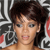 Pixelated image of a person with short dark hair, light skin, and visible eyes and mouth against a patterned background with red and white elements.