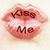 Pixelated icon of pink lips with dark brown text reading "Kiss Me" in a stylized font, set against a light beige background.