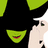 Pixelated character with green hair and black clothing, showing partial face and hand gesture against dark background with green text.