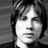 Black-and-white portrait of a person with tousled hair on left, green background with pixelated text 'EVAN !!!!!' on right.