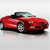 Red convertible sports car with black soft top and silver wheels on light gray background.