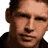 A pixelated portrait of a person in a dark hoodie with repeated text overlays reading CHAD LAMARSH and .COM on a black background.