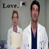 Two people in white lab coats stand side-by-side against a gray wall with the word 'Love.' in black text above them.