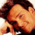 Pixelated close-up of a person with dark curly hair, light skin tone, and closed eyes resting on a white background.