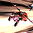 Pixelated character in orange and pink clothing with black limbs, positioned on a light brown background beneath bold text reading 'Xenosaga' and 'GAME LAUNCH 02.25.03'.