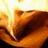 A pixelated image with a dark red background, featuring a blurry orange-brown shape on the left and yellow text on the right.