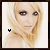 Pixelated portrait of a person with long blonde hair, brown eyes, and light skin; two identical side-by-side frames show subtle facial expression differences.