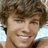 A pixelated image of a smiling person with brown hair on the left, next to red and gray sections containing text.