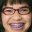 Pixelated image of a person with red-framed glasses and braces, next to blue pixelated text on black background.