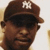 Two side-by-side pixelated portraits of a person wearing a brown cap with white 'NY' logo on left and dark beret on right, both against light background.