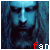 Pixelated blue-toned image of a person with long hair and a beard, featuring red and white text at the bottom.