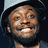 Pixelated image of a person wearing a light-colored cap and dark clothing, with pink pixelated text on black background.