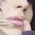 Pixelated close-up of a person's face showing lips, eyes, and part of the nose with visible teeth.