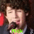 four pixelated images showing a person with curly hair holding a microphone, each with a different name label in green text
