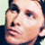 Pixelated close-up of a person's face showing eyes, nose, mouth, and ear with dark hair against light background.