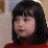 A young girl with dark hair and bangs appears in three distinct poses: looking left, smiling, and resting her head on her hand.