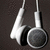 White over-ear headphones with dark gray earcups hang against a dark gray background, showing slight variations in position across frames.