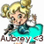 Pixelated character with blonde hair in a bun, wearing a teal dress and holding a black microphone against white background.