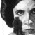 Black-and-white pixelated static image of a human face with dark hair, visible eye, nose, and mouth features on a transparent background.